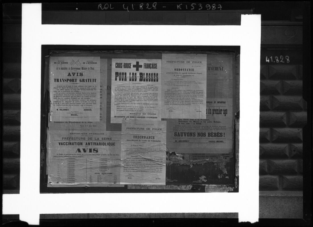 Photographie noir et blanc d'un panneau d'affichage parisien couvert d'avis officiels de 1914, dont une ordonnance de la préfecture de police interdisant la vente d'absinthe.